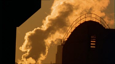 Smoke rises beside a docked ship