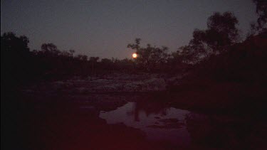 Moon in night sky, reflection of moon in water
