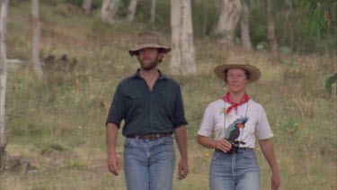 Man and women walking, stop, women puts binoculars to her eyes