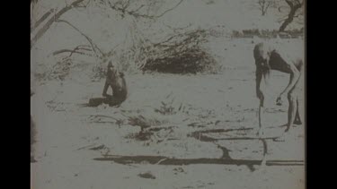 Black And White Shot Of Aboriginal Man Cooking A Dingo Carcass