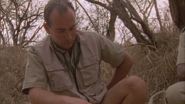 front on of scientist Andrew Parker taking GPS reading of leopard tracks