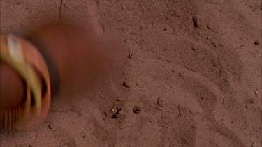 bushman woman picking out and throwing poison arrow worms to little boys, hand picking up the beetle larvae