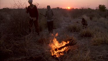 bushmen hunters starting fire .trying to get warthog out of hole by starting fire