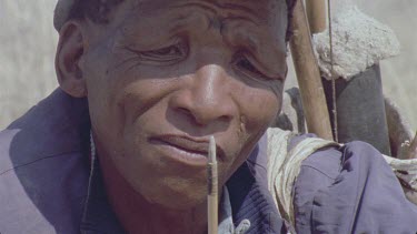 one bushman with his arrow twirling in front of face