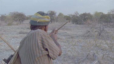 bushman aiming bow and arrow at prey