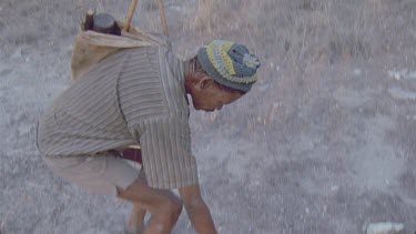 bushman picking up arrow off ground that missed its quarry