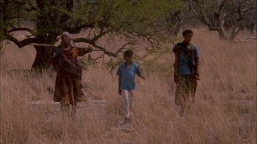 bushmen boys and women babies and coming back to camp through bush