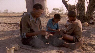 bushmen chews grass to make saliva which he adds to crushed larvae of Diamphidium beetle boys prepare sinew to warp around arrow