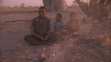 bushman squeezing poison from grub then dab poison onto arrow shaft