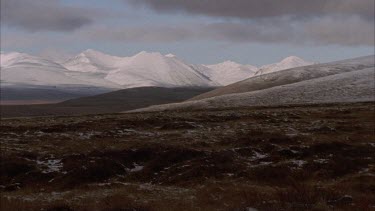 Tundra landscape snow covered mountains in background