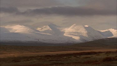 snow capped mountains in tundra landscape.