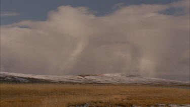 clouds moving over lake, snow covered foreground