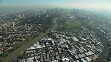 Aerial. Melbourne. City skyline and Yarra river. Bridges. Office blocks, towers. MCG Melbourne Cricket Grounds. Rod Laver Arena