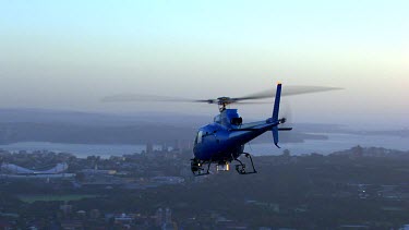 Sydney at sunrise. Helicopter and early morning light. Very blue light and metallic blue helicopter.
