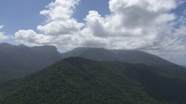 Forested mountain peaks and a shallow stream running through Daintree National Park