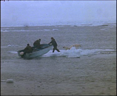 Men with small boat on ice floe with polar bear