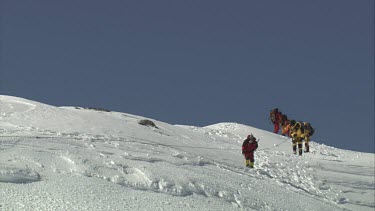 Aerial of Mount Everest: Climbers carrying troubled climber to mouintain peak