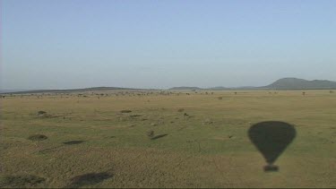 Aerial view of Serengeti National Park. Shadow of hot air balloon over the African savannah plains.