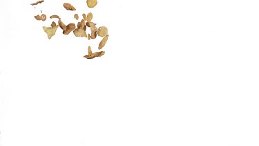 Corn Flakes Falling against White Background, Slow Motion