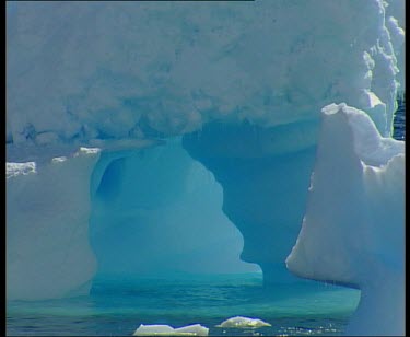 Archway in ice. Cold blue ice as sun shines through