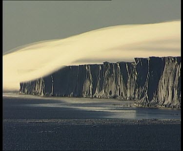 Thick layer of very low cloud over coastal cliffs, like a tablecloth.