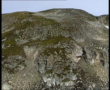 Zoom out. Rugged rocky landscape.