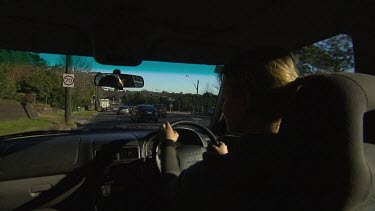 Point of View POV driving in a car, highway (over shoulder of woman driving).