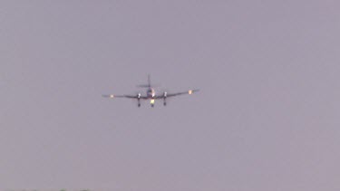 Small propeller plane landing dunes of dirt in background. Heat haze.