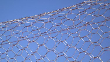 Barbed wire fence against blue sky