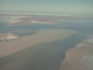 Desert below, close up of plane wing.  Lake Eyre, flooded