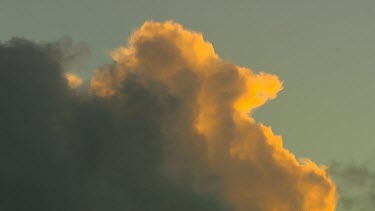 Clouds at sunset, pinks, light oranges. Clouds in shadow or silhouette. Dark clouds blow in the wind.