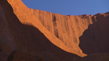 Rounded rocks Uluru. Red against blue sky.