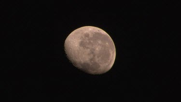 Full moon setting in dark night sky