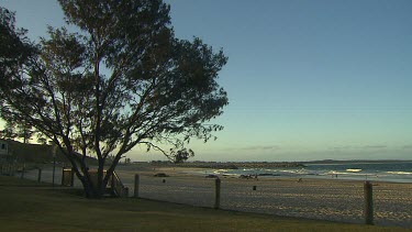 Port Macquarie beach late afternoon shadows, sense of cool air.  Few people on beach