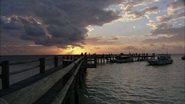 Long shot pier jetty dock sunset, people looking at water