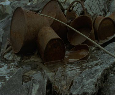 Mawson's Huts. Cape Denison Commonwealth Bay. Australian Antarctic Territory. Ice has thawed into rivulets of water flowing over debris of rusting cans.