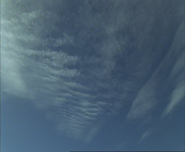 One man camping in snowy white landscape Wide shot sky is bright blue with few scattered wispy sirrus clouds.