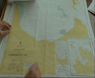 Hand pointing at map, chart of Commonwelath Bay, Australian Antarctic Territory.