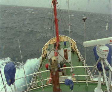 Bow, prow of ship moving through rain and stormy seas.