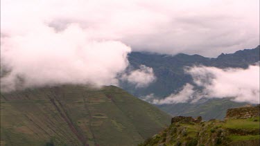 Pan across a mountain side village ruins in Peru