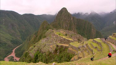 Machu Picchu with clear skies, a few tourists walking around