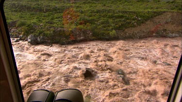 View of rapids in the Urubamba river from a train window. River is very close to the tracks