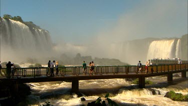 Tourists walking across the walkways at Iguaz Falss