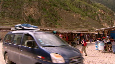 Panning up to the stone terraces from a market place in Ollantaytambo