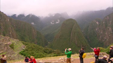 Panning across Machu Piccu with tourists in the fore ground