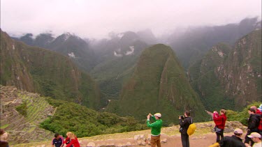 Panning across Machu Piccu with tourists taking photo's in the fore ground