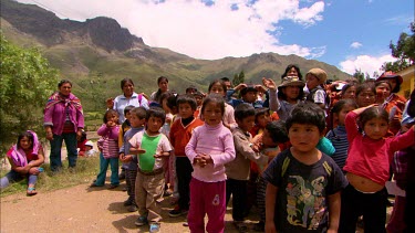 A group of school kids and teachers gathered outside, waving