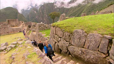 Tourist walking through the rock terraces in Machu Picchu