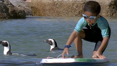 Children swimming in FG penguins swimming in BG