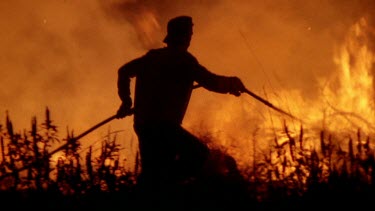 Fireman with hose tries to put fire out